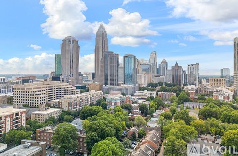 A cityscape with tall buildings and greenery in the foreground.