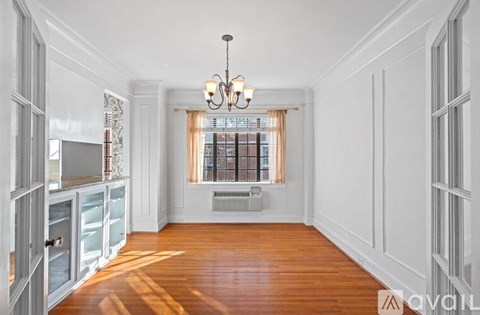 A spacious room with wooden floors and white walls.