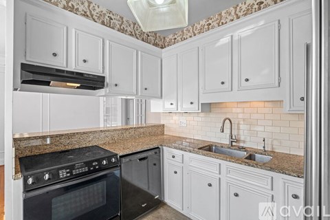 A kitchen with white cabinets and a black oven.