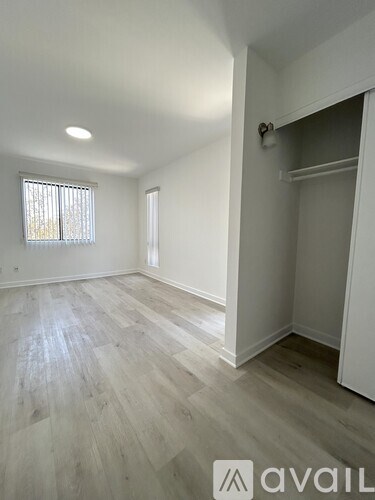 A room with a window and a wooden floor.