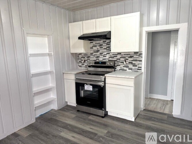 A kitchen with white cabinets and a black stove top oven.