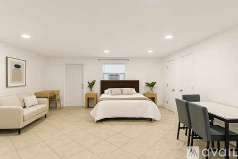 A bedroom with a bed, couch, and table.