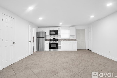 A spacious kitchen with white cabinets and appliances.