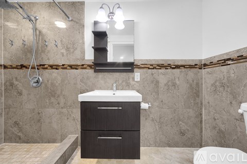 A bathroom with a sink, mirror, and shower.