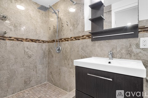 A bathroom with a white sink and a tiled shower.