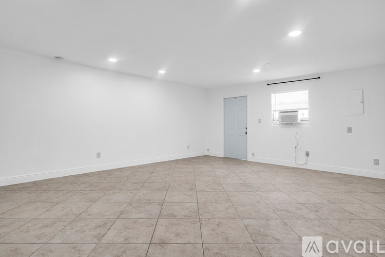 A spacious empty room with a door and a window.