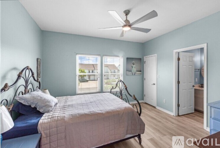 A bedroom with a bed, dresser, and window.