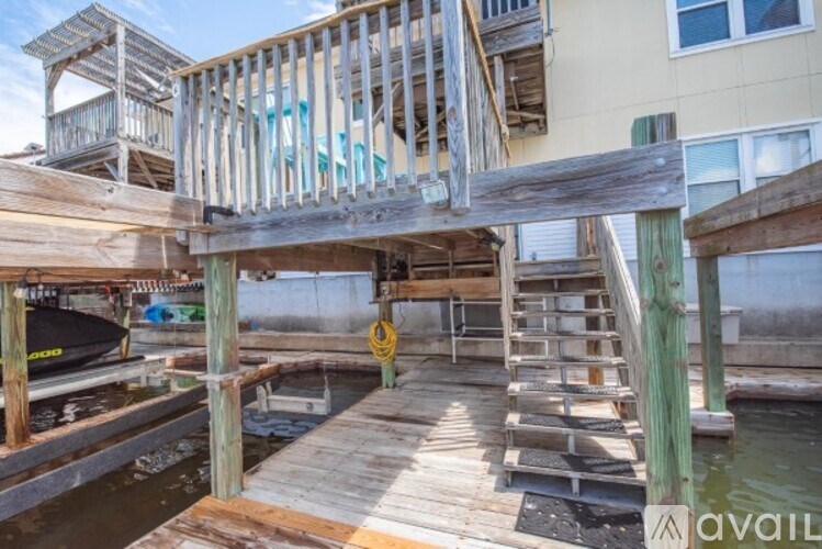 A wooden dock with a boat and a building in the background.