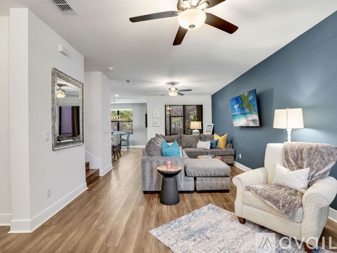 A living room with a white couch and a grey armchair.