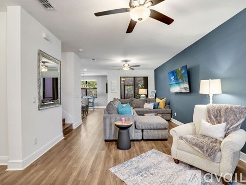 A living room with a white couch and a grey armchair.