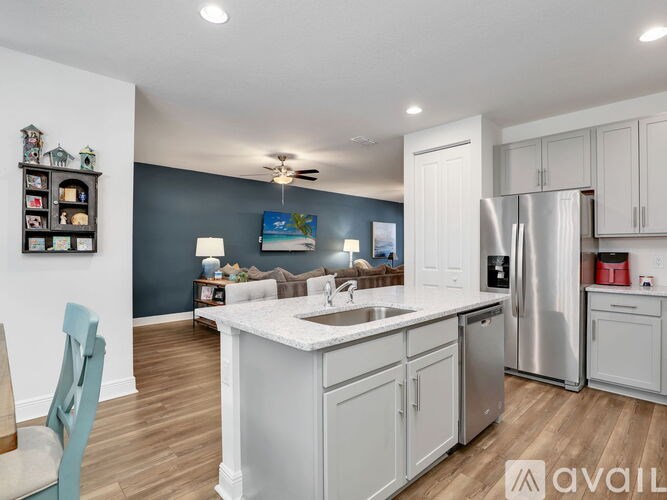 A kitchen with white cabinets and a stainless steel refrigerator.