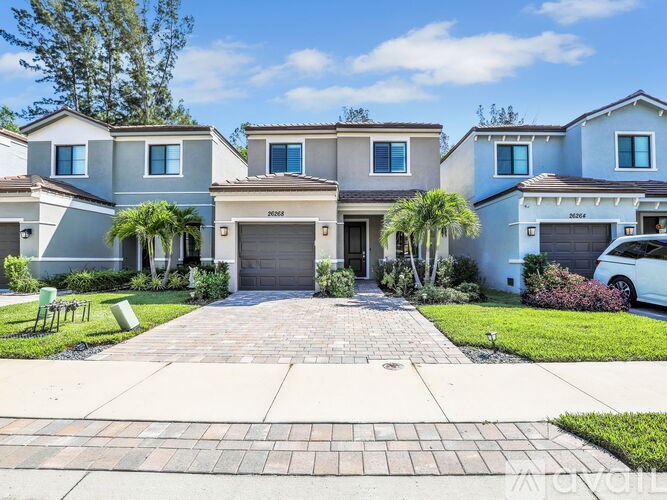 A row of houses with a driveway in front.