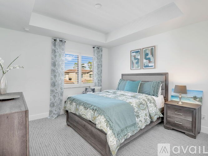 A bedroom with a large bed and a nightstand with a lamp on it.