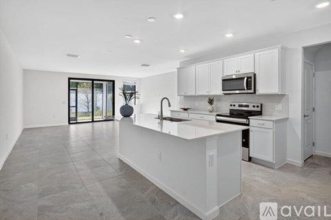 A modern kitchen with white cabinets and a large island.