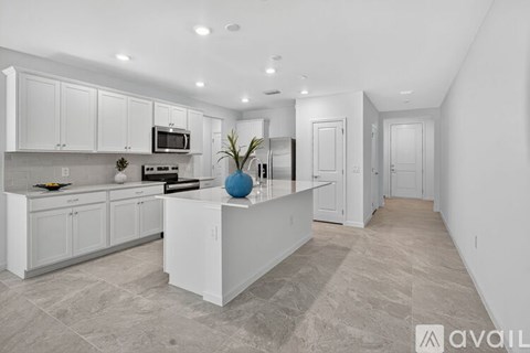 A modern kitchen with white cabinets and a central island.