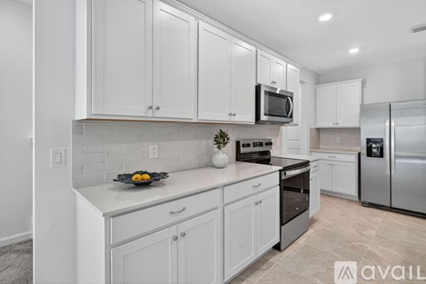 A kitchen with white cabinets and appliances.