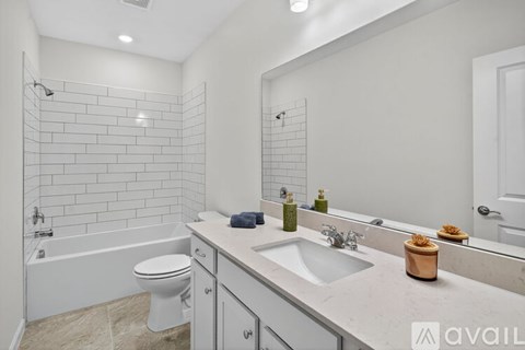 A bathroom with a white tub, sink, and toilet.