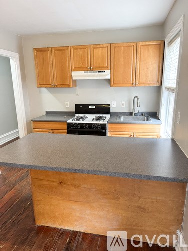 A kitchen with wooden cabinets and a stove top oven.