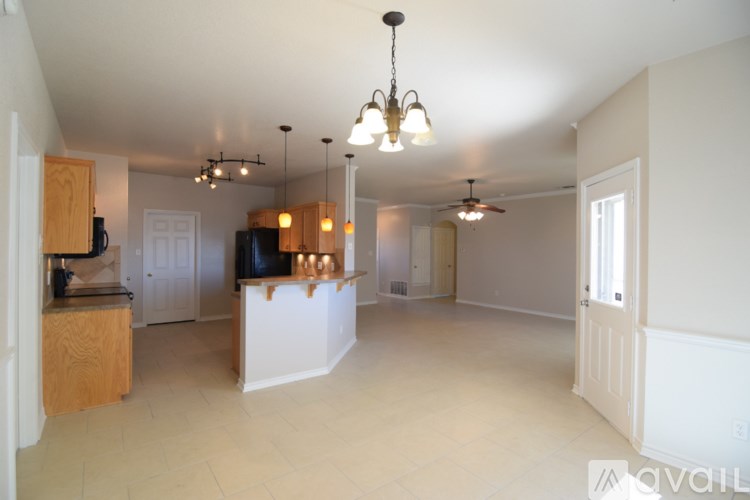 A large open living room with a kitchen area in the background.
