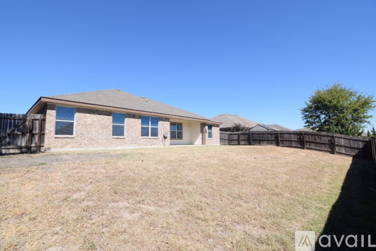 A house with a fence and a tree in the front yard.