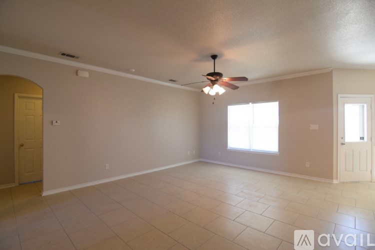 A spacious room with a ceiling fan and tile flooring.