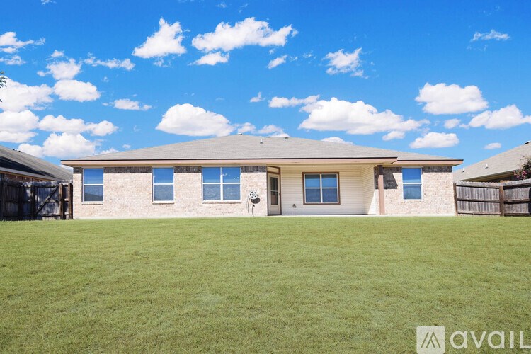 A house with a brown roof and a fence in front of it.