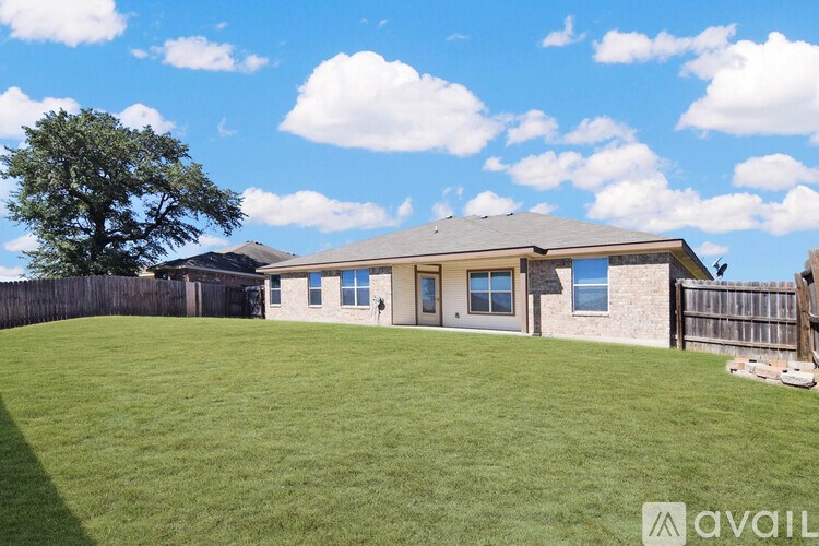 A room with a ceiling fan and a window letting in sunlight.