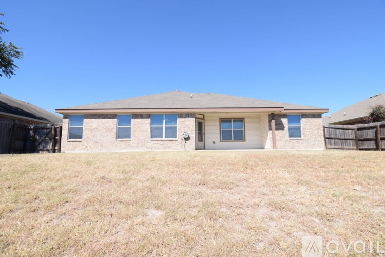 A house with a brown roof and a fence in front of it.