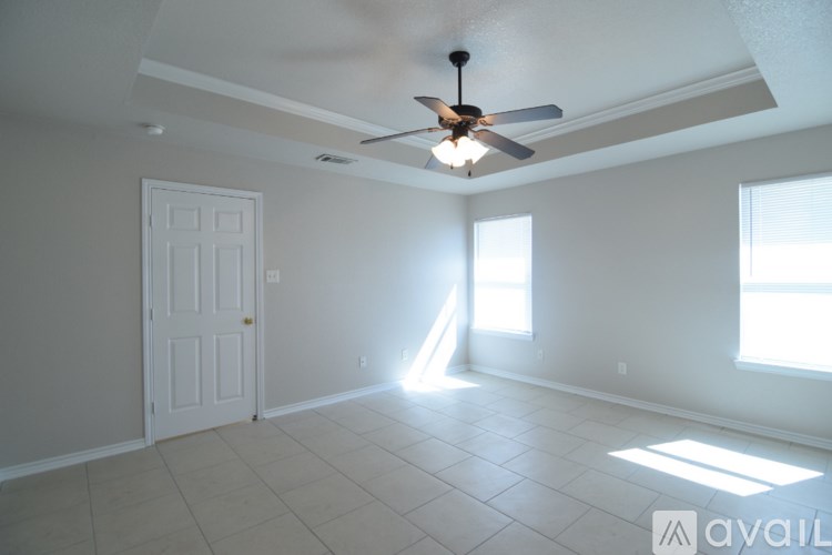A room with a ceiling fan and a door.