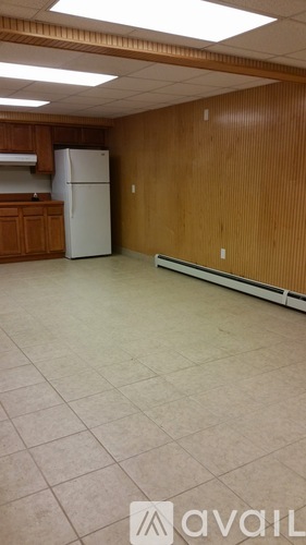 A kitchen with a white refrigerator and wooden cabinets.