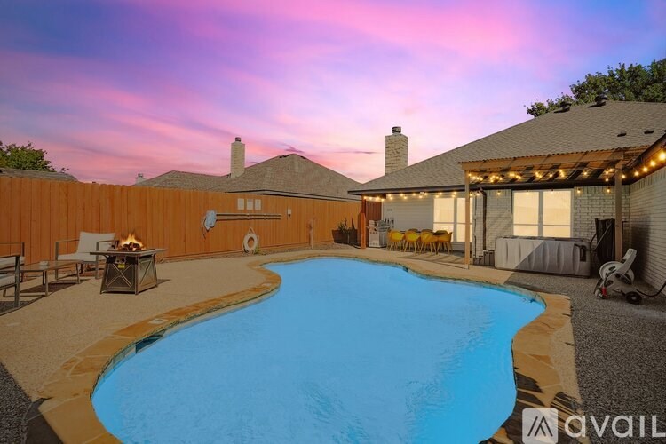 A backyard with a pool and patio furniture.