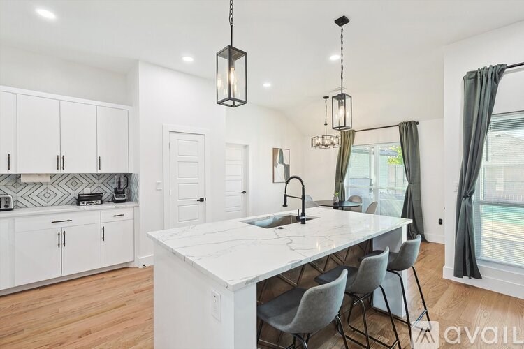 A kitchen with a white countertop and grey chairs.