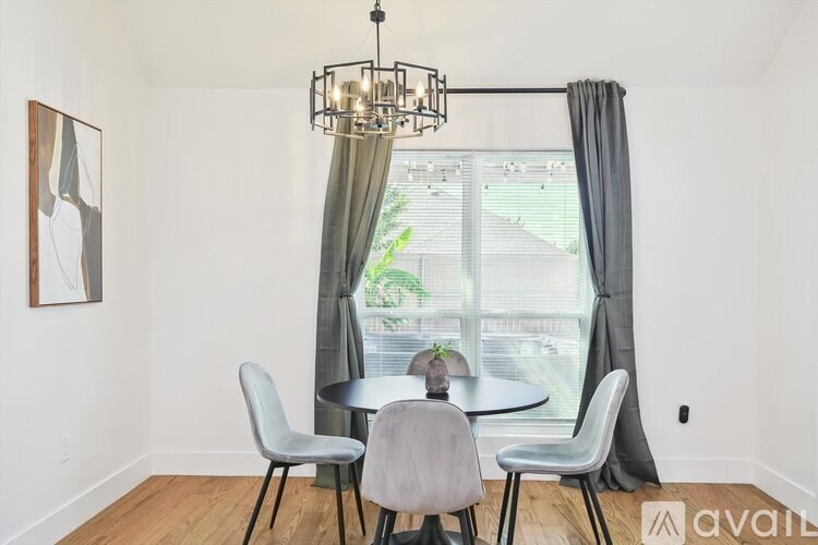 A dining room with a table and chairs and a chandelier.