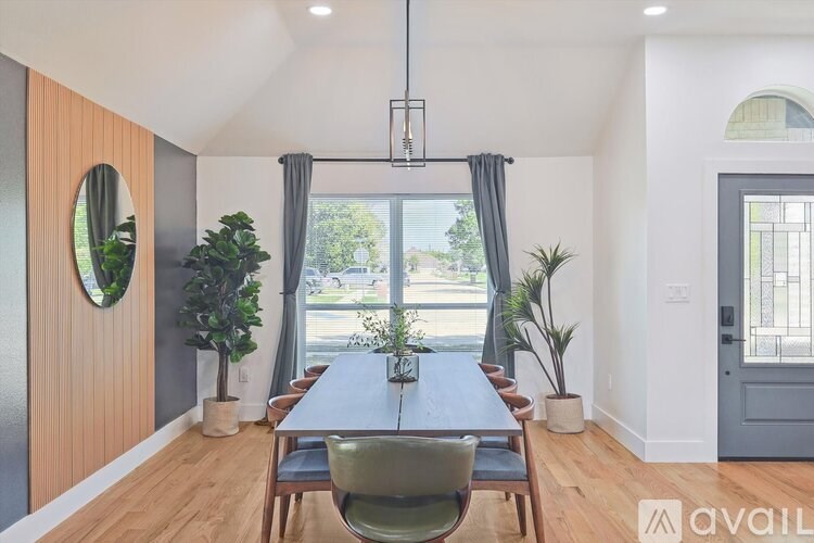 A modern dining room with a wooden table and chairs.