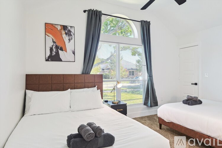 A bedroom with a large bed and a painting on the wall.