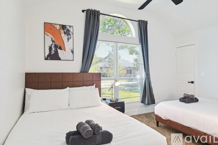 A bedroom with a large bed and a painting on the wall.