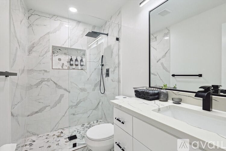 A bathroom with a marble patterned shower and toilet.