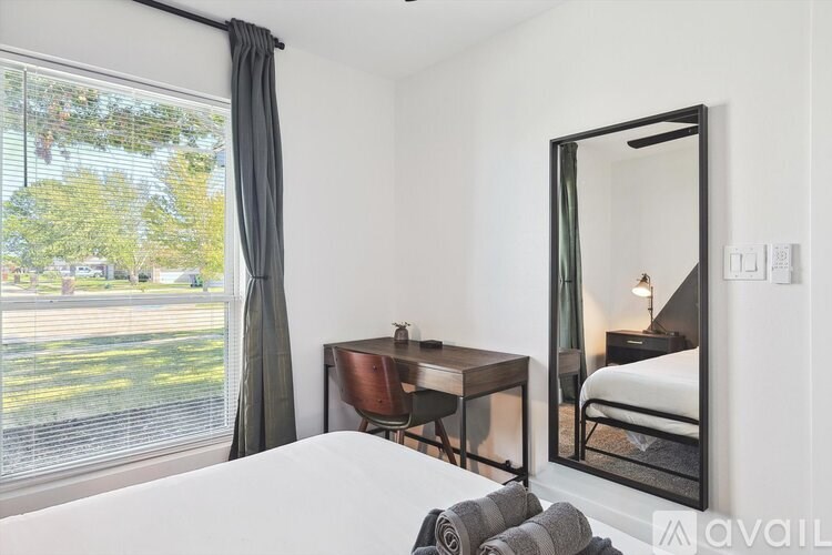 A bedroom with a large mirror and a bed.