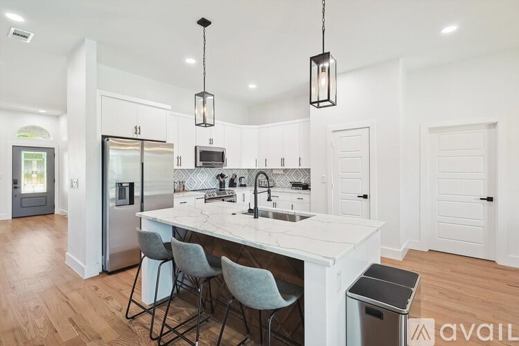 A kitchen with a large island and a refrigerator.