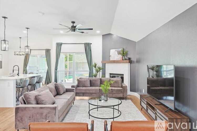 A living room with a grey couch, a coffee table, and a television.