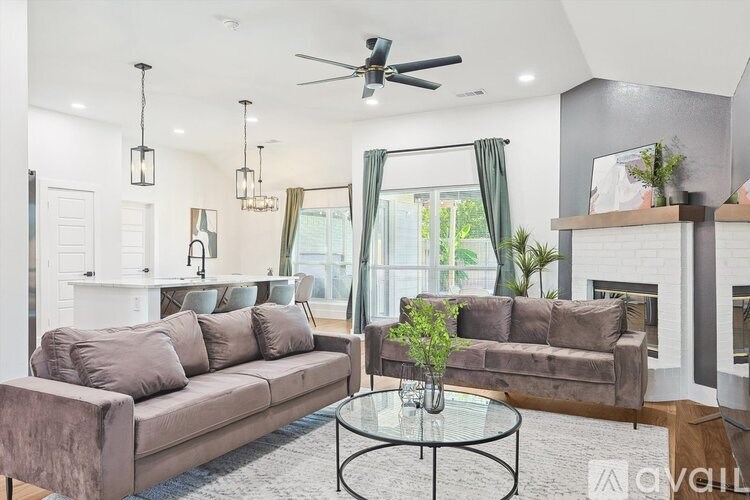 A living room with a brown couch and a glass coffee table.