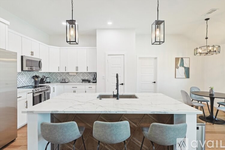 A kitchen with a white table and chairs.