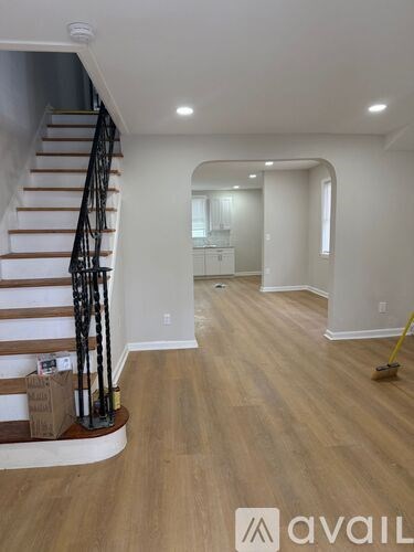 A room with wooden floors and a staircase with a metal railing.