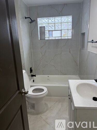 A bathroom with a toilet, sink, and bathtub.