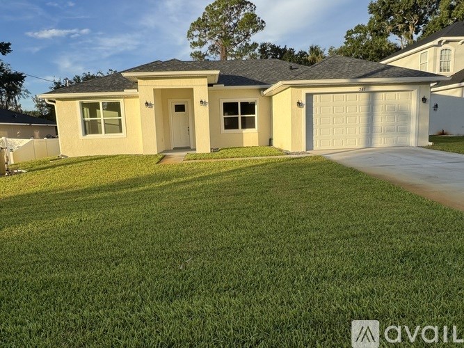 A house with a garage and a driveway in front.
