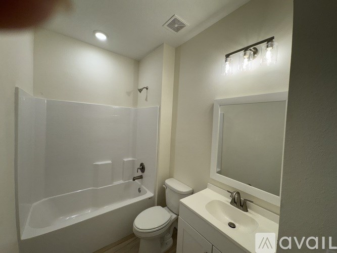 A bathroom with a white tub, toilet, and sink.