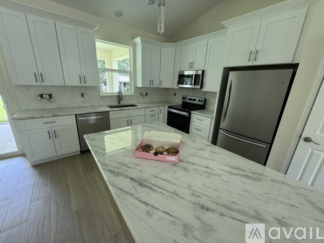 A kitchen with a marble countertop and stainless steel appliances.