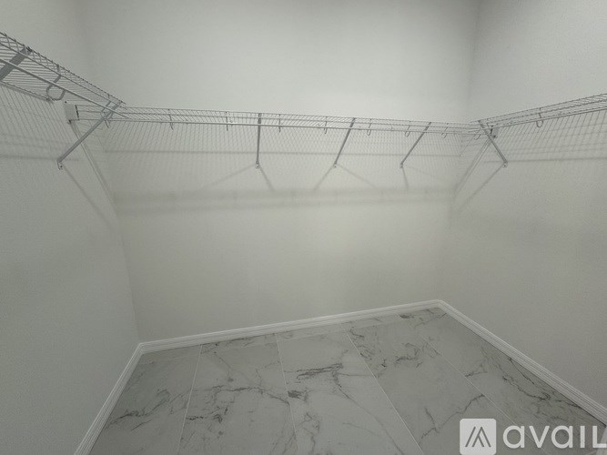 A room with a marble floor and clothes hangers.
