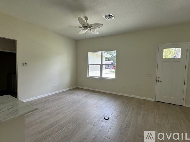 A room with a ceiling fan and a window.