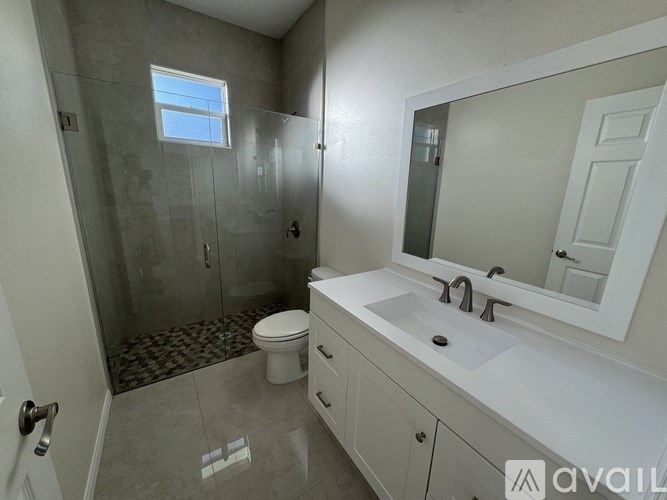A bathroom with a toilet, sink, and shower.